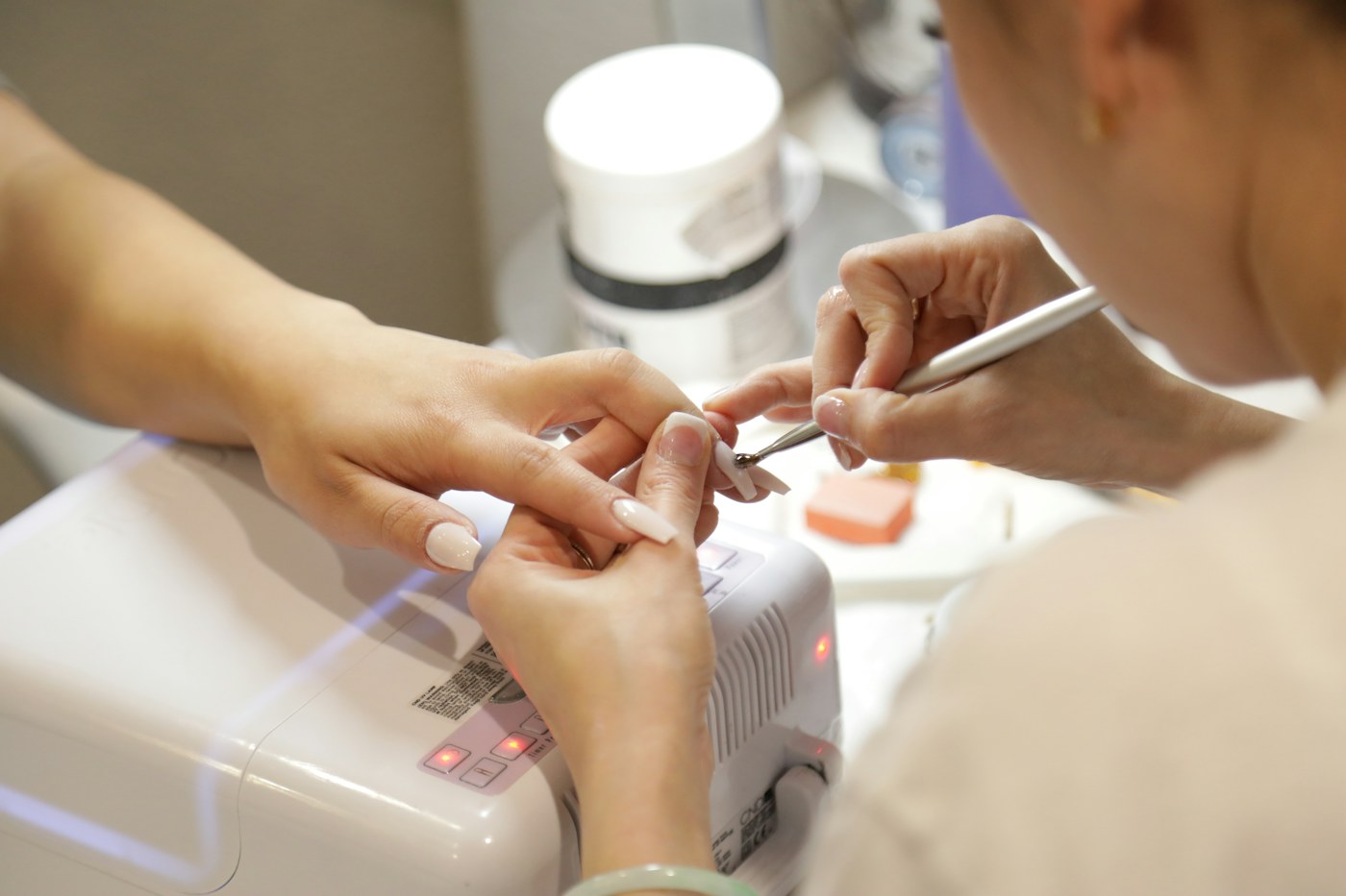 A nail technician carefully shaping a client's nails